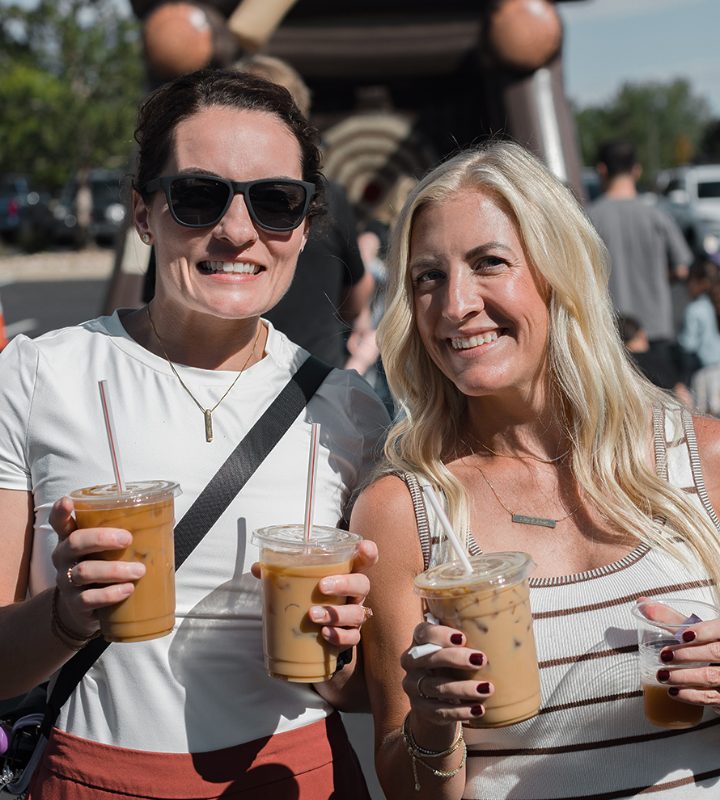 Two friends holding iced drinks from the food trucks